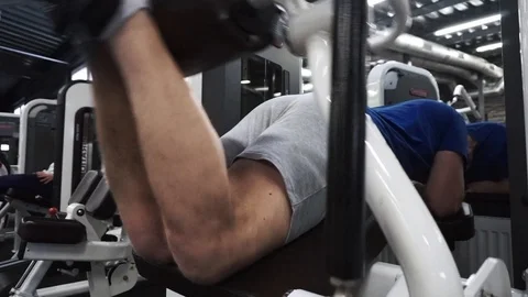 Medium shot Man lying workout in leg machine. Exercise for lower body in the gym Stock Footage 102332154