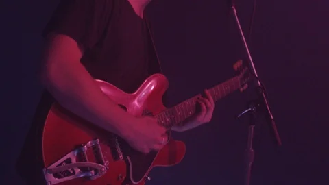 Medium shot of a man playing electric guitar on stage Stock Footage 127135695