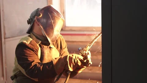 Medium shot . A man in a protective mask works with a welding machine. Stock Footage 196879592