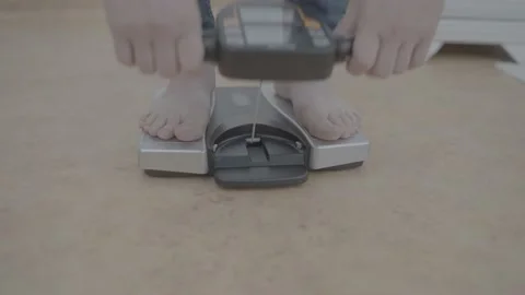 Medium shot man pull up the electronic display of parameter of the smart scale Stock Footage 219502513