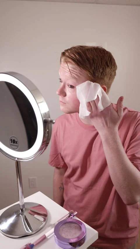 A Medium Shot of a Man Removing Makeup with Wipe in Front of Mirror Stock Footage 310224725