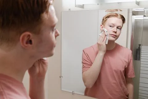 A Medium Shot of a Man Removing Makeup with Wipe in Front of Mirror Stock Photos
