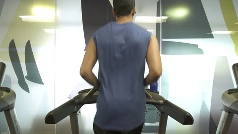Medium shot of a man running on a treadmill Stock Footage 76540538