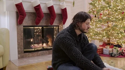 Medium shot of a man tying a bow on a gift for Christmas Video stock 73032217