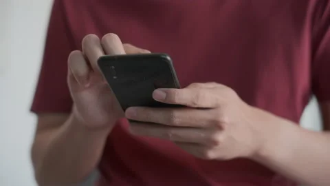 Medium shot man typing scrolling and reading with his cell phone. 스톡 동영상 169019400