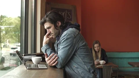 Medium shot of man using a laptop in a coffee shop 動画素材 76538902