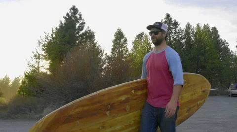 Medium shot of man walking with paddle board Video stock 62839472