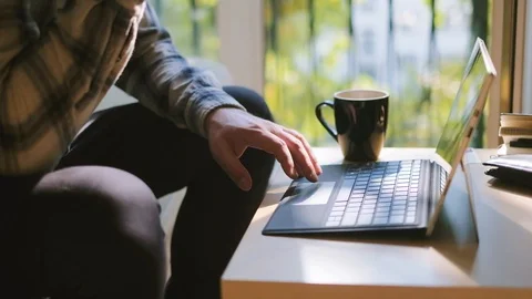 Medium shot of man working on laptop at home office Видео 95392125