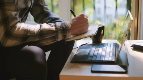 Medium shot of man working on laptop at home office Stock Footage 95392216