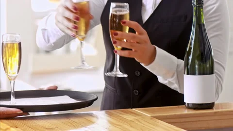 Medium shot of manager helping waiter with tray, to deliver full champagne glass Stock Footage 199633705