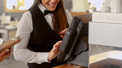 Medium shot of manager swiping touch payment terminal as waitress picking up tab Stock Footage 199633828