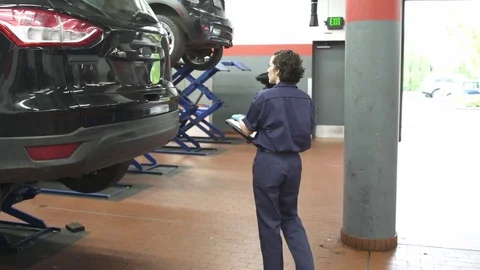 Medium shot of a mechanic examining a car 動画素材 76233440