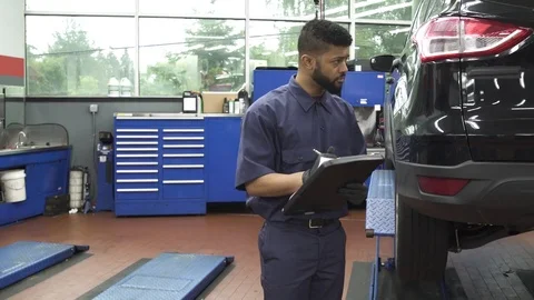 Medium shot of a mechanic taking notes 動画素材 76538575