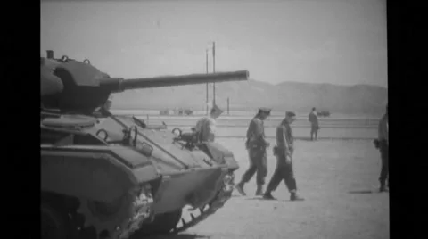 Medium shot of military soldiers walking by military tank Stock Footage