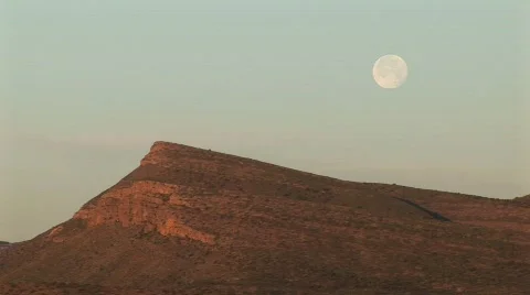 Medium-shot of the moon hovering over a rocky landscape Stock Footage 440028