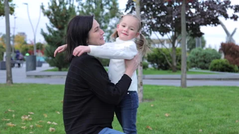 Medium shot of a mother gently hugging her daughter. Cute innocence child girl Stock Footage 188962645