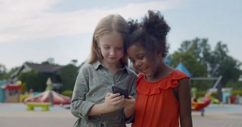 Medium shot of multiracial kids using cellphone at playground Stock Footage 159819375