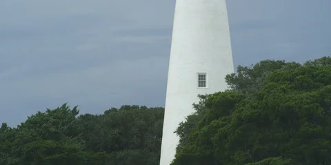 Medium shot of Ocracoke lighthouse and green trees Stock Footage 103490104