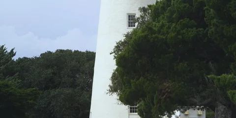 Medium shot of Ocracoke lighthouse and green trees Stock Footage 103490459