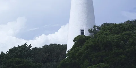 Medium shot of Ocracoke lighthouse and green trees Stock Footage 103490488