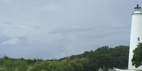 Medium shot of Ocracoke lighthouse surrounded with green trees Stock Footage 103490317