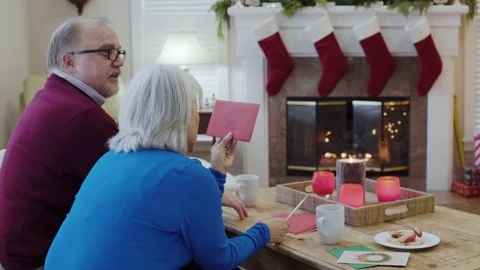 Medium shot of an old couple opening a greeting card 動画素材 73114048