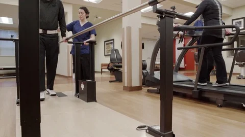 Medium shot of an old man walking in parallel bars Video stock 71827606