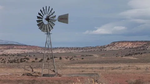Medium shot of an old windmill standing on a desert plain Stock Footage