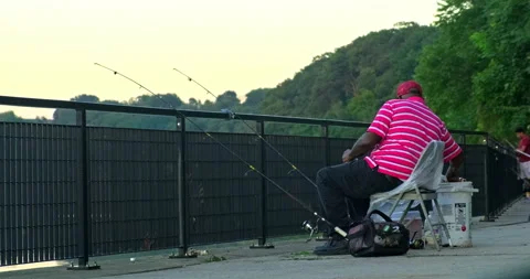 Medium shot of an older man putting away his fishing supplies while fishing Stock Footage 203839772