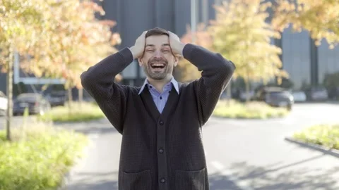 Medium shot of one excited man cheering, cinematic style, autumn park. Video stock 331820071