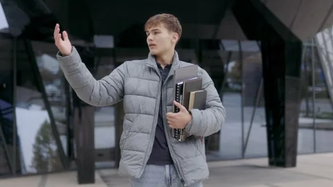 Medium shot of one young man checking for rain in modern urban style. Video stock 332766112