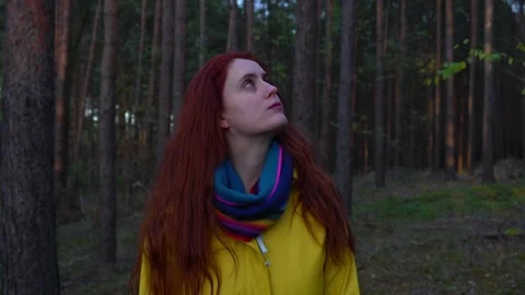 Medium shot of pale red haired woman looking around in forest during day Stock Footage 134878624