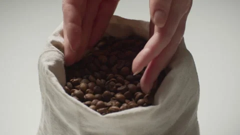 Medium shot part closeup of a woman's hand taking a handful of coffee beans and Stock Footage 241357605