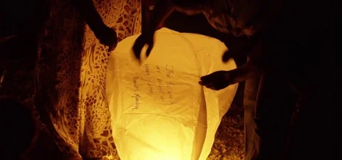 Medium shot of people lighting sky lantern 動画素材 73550875