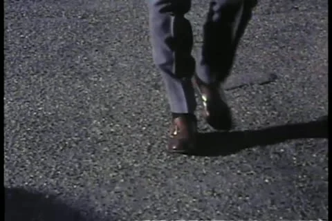Medium shot of person's feet and legs walking on asphalt Stock Footage 11348656