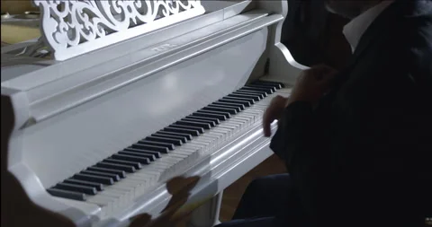 Medium shot of a pianist starting to perform his own music Stock Footage 198741133