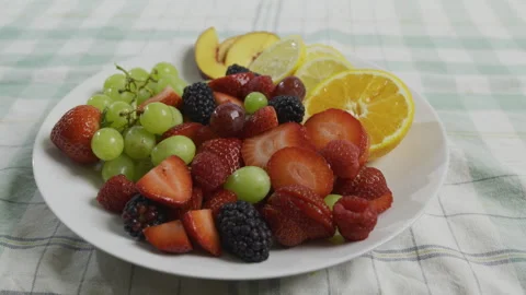 Medium shot of plate filled with strawberries, oranges, lemons, grapes, Stock Footage 341205566