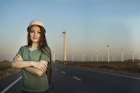 Medium shot portrait of a smiling young female engineer in a safety helmet, a Stock Photos