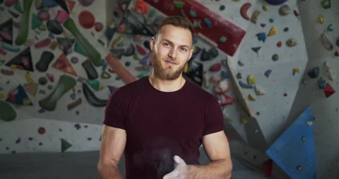 Medium shot portrait of a young bearded smiling climber athlete in a gym Stock Footage 131351167