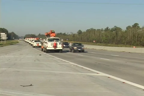 Medium shot of  power and utility trucks rushing to restore power to hurricane Stock Footage 551627