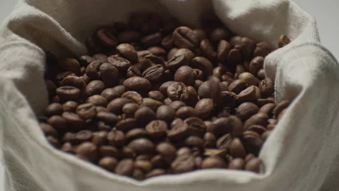 Medium shot of a rag bag with black coffee. Coffee beans fall into a rag bag Stock Footage 241353935