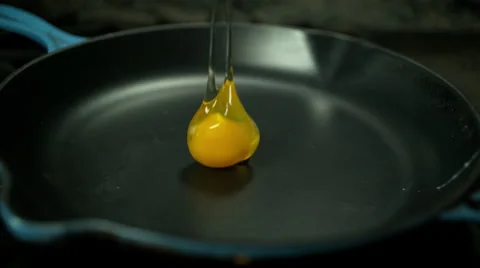 Medium shot of raw egg falling into hot pan in slow motion 스톡 동영상 60140751