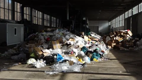 Medium shot of recycling facility interior with large pile of waste Video stock 278512871