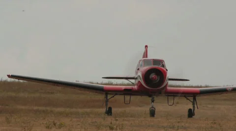 Medium shot of red plane Yakovlev Yak-18T rides on the field Stock Footage 38391610