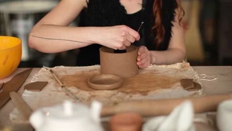 Medium shot of a redhead ceramic artist sculpting a bowl in the studio Stock Footage 236372682