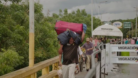 Medium shot of refugee man crossing the Colombia-Venezuela border Stock Footage 101307265
