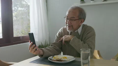 Medium shot : Retired gray haired grandpa asian man sit alone using mobile Stock Footage 140779177