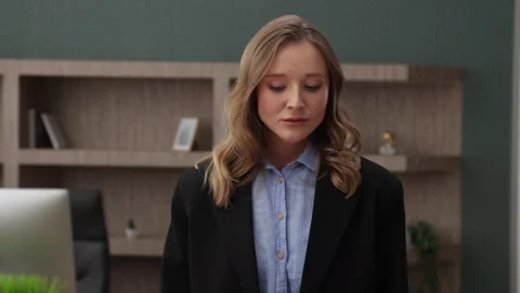 Medium shot of sad attractive young blonde in formal outfit standing in office Stock Footage 249027036