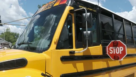 Medium shot of school bus with stop sign extended and flashing Stock Footage 138120002
