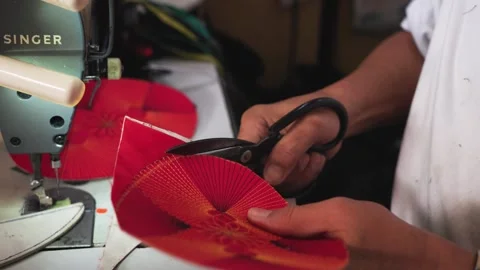 Medium shot of scissors cutting red fabric for a songkok top panel in Malaysia Video stock 333409826